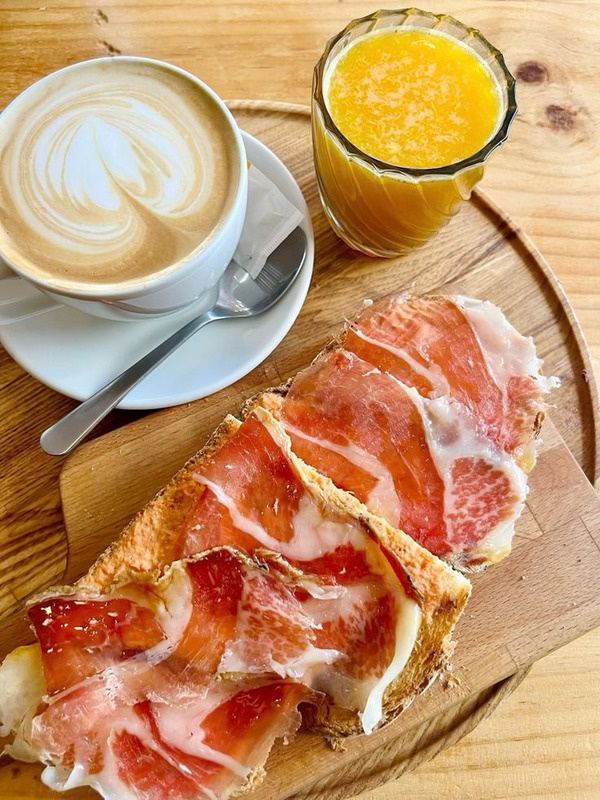 Café con leche, zumo de naranja y tostada con jamón